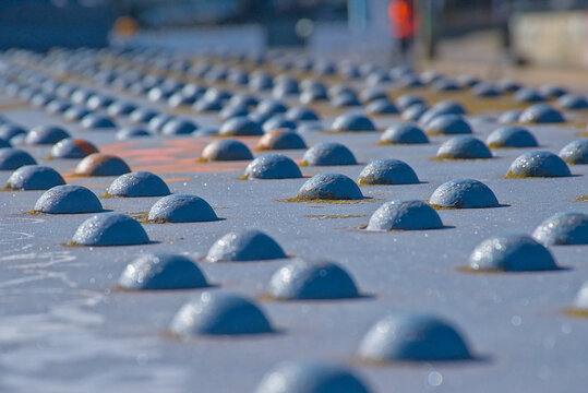 closeup of blue painted industrial metal rivets, selective focus with blurry background. detail of a bridge 
