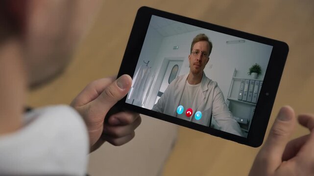 Doctor talking pad screen at hospital interior closeup. Man hands video call