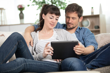 Obraz premium couple using a tablet computer in their living room