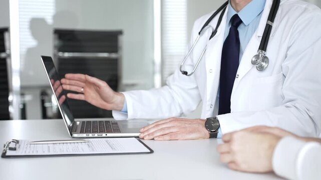Male doctor communicating with patient at a clinic desk, offering professional healthcare guidance and explaining a diagnosis. Medicine, healthcare and science concept