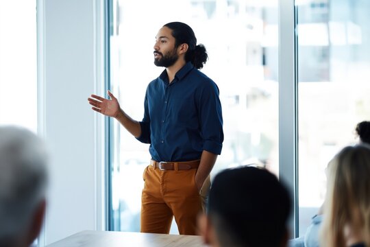 Man presenting with hand in pocket to office audience