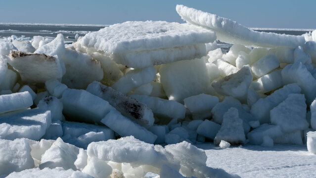 Massive ice hummocks on a sandy beach in spring