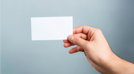 Fototapeta premium Hand holding blank white horizontal card, presenting empty space for text and custom branding