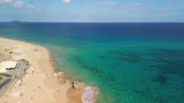 Aerial view of drone flying over golden sand beach with a small rock island in Porto Santo, Madeira, Portugal. Portuguese paradise with clean transparent water.