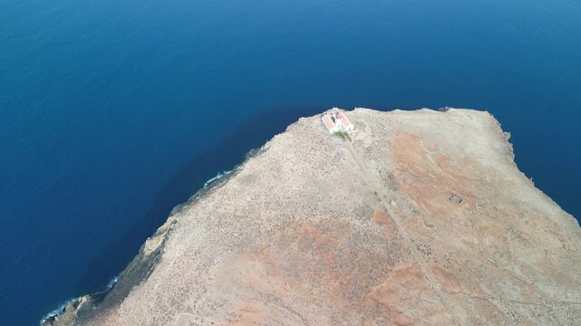 Aerial drone view over a rocky tiny island (Ilheu) with a light house. Volcanic scenic view in Porto Santo island, Madeira, Portugal