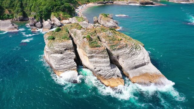 Rugged cliffs by turquoise waters, waves crashing on rocks, patches of greenery adding contrast and a nearby beach area, blending natural beauty, lively charm. Sardalya Bay, Kandıra, Kocaeli, Turkey 
