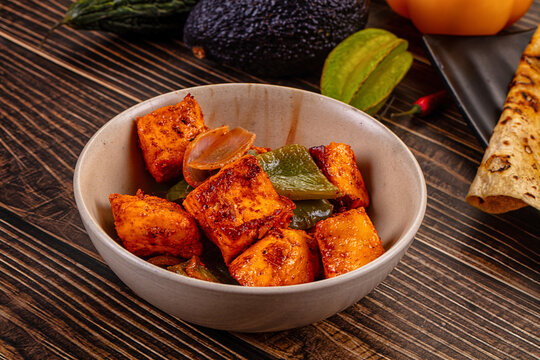 Indian Paneer Tikka Masala inl with Roti bread on a dark wooden table