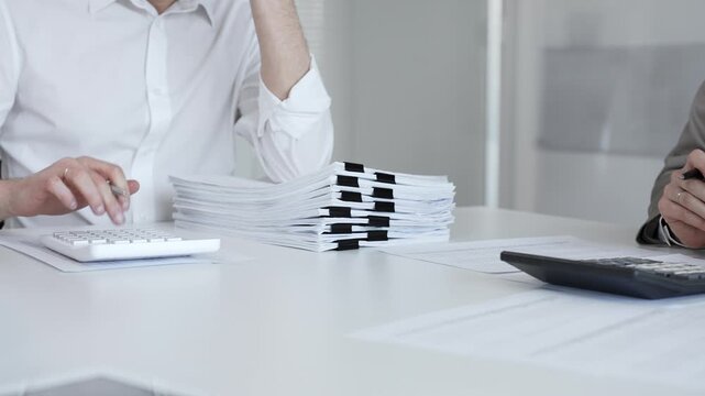 Businesspeople analyzing financial documents and tax forms, planning business strategy, making financial decisions. Audit and taxes in business