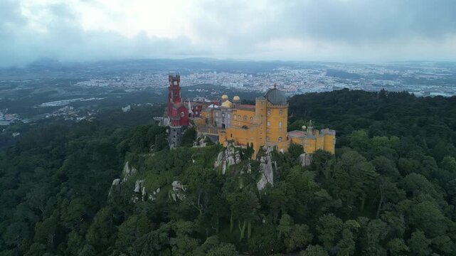 Aerial drone view around Pena Palace, a cozy colorful castle from ex Portuguese monarchy. Sintra town, Lisbon, Portugal