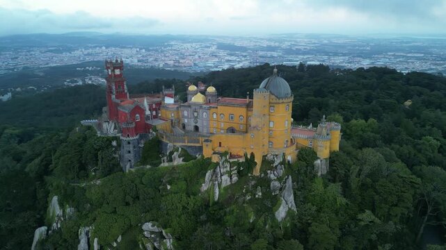 Aerial drone view around Pena Palace, a cozy colorful castle from ex Portuguese monarchy. Sintra town, Lisbon, Portugal