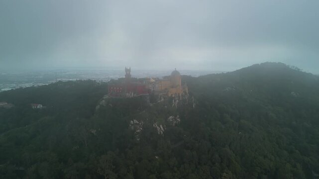 Aerial drone view around Pena Palace, a cozy colorful castle from ex Portuguese monarchy. Sintra town, Lisbon, Portugal