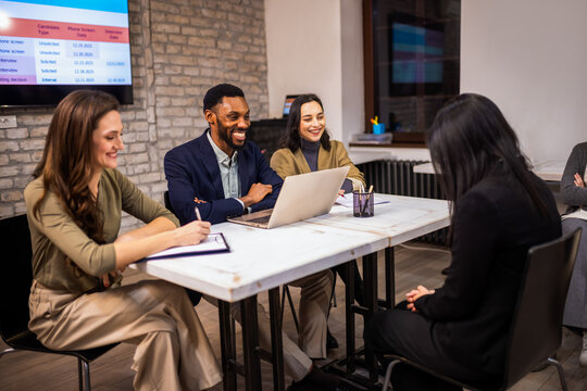 Professional hiring committee conducting a job interview in a modern office environment.