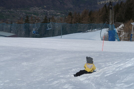 Toddler Sitting in Snow, Back View, Winter Landscape in Pila Above Aosta, Italy
