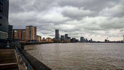 Fototapeta premium Modern Residential Buildings Along the River Thames under a Cloudy Sky, London