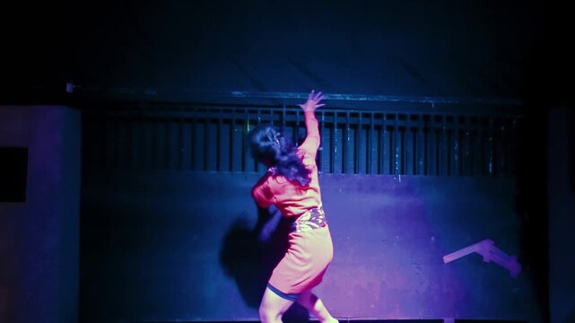 Expressive Dance of Anguish by a Woman in a Blue-Lit Space
