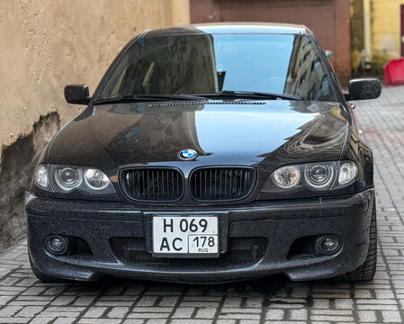 Black BMW 3 series IV E46 ZF MT M-tech in a parking lot. Motor car BMW E46 3-series parked on street. Exterior of the BMW 3 Series E46 black color. Germany classic sedan car. 