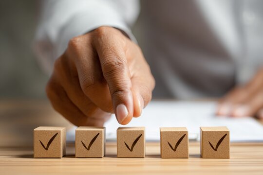 Hand of african adult male pointing at checked wooden blocks on desk