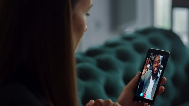 Businesswoman video calling subordinate by smartphone at home close up.