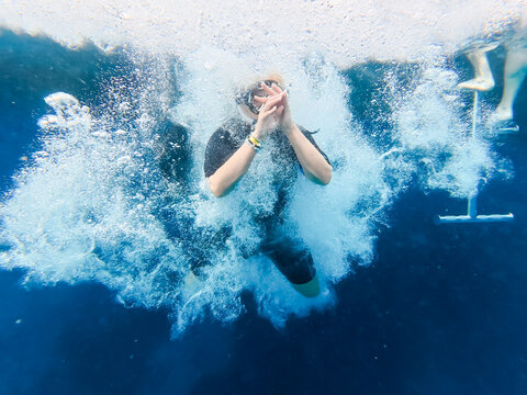 Young Woman Jumping from a Boat into the Crystal Clear Blue Water of Ras Mohammed National Park in Egypt