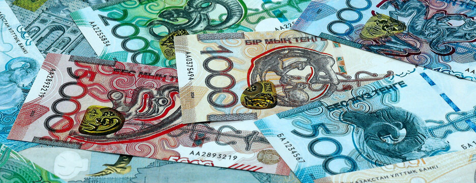 Kazakhstani tenge money banknotes pile on table. Kazakhstan bills of KZT currency close up