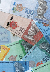 Malaysian ringgit money banknotes pile on table. Malaysia bills of MYR currency close up © Larysa