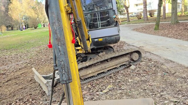 Mini excavator parked on a construction site, close-up.