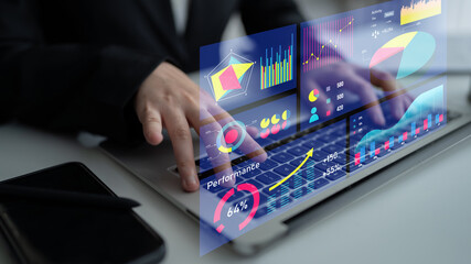 Fototapeta premium A businessman interacts with a laptop displaying performance data and interactive graphs, illustrating the role of technology in strategic decision making. Impute