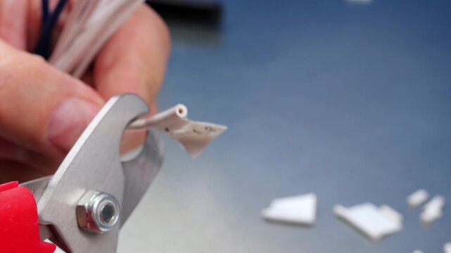 Cutting copper electrical wires with wire cutters. 