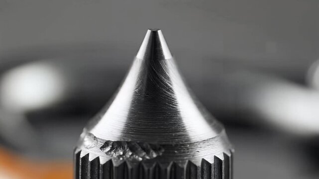 Close up macro shot of a metal vape pen tip with a sharp point.
