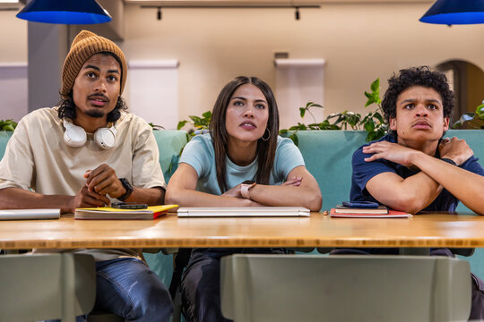 Students with teen sitting together at study lounge studying with silver laptop and notebooks