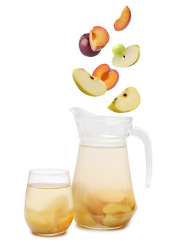 Tasty fruit compot and falling ingredients on white background