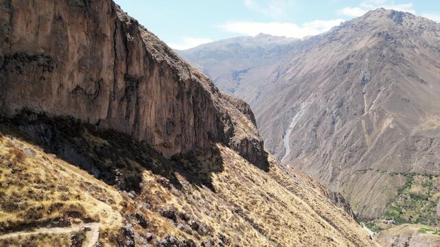 Drone flight over the deep Colca Canyon with steep cliffs and mountain ranges, Peru