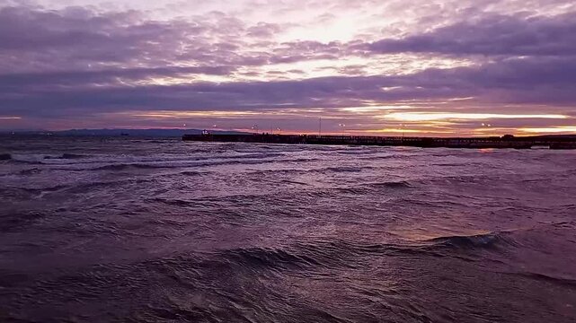 Scenic View of Choppy Sea Waves and a Long Pier During a Dramatic Purple and Orange Sunset in Sarkoy, Tekirdag, Marmara Sea, Turkey.