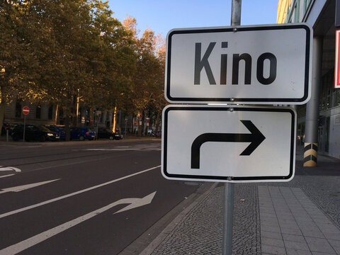 Kino-Wegweiser mit Rechtsabbieger-Pfeil in der Stadt &ndash; Orientierung