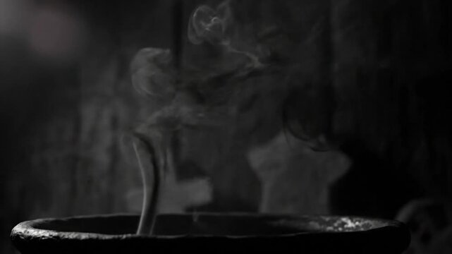 Mysterious steaming cauldron with swirling smoke in a dimly lit, dark, and gothic atmosphere