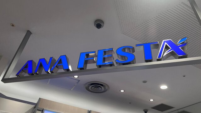 ANA FESTA airport souvenir shop storefront with illuminated blue brand logo signage at Narita International Airport (NRT) terminal - Chiba, Japan, October 29, 2025