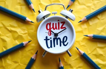 Fototapeta premium Alarm clock shows quiz time surrounded by sharpened pencils on yellow crumpled paper background. Education learning knowledge test preparation concept.