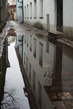 1 . Reflection of a white building in a narrow puddle