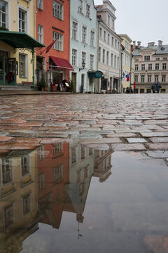 Colorful houses reflected in a street puddle