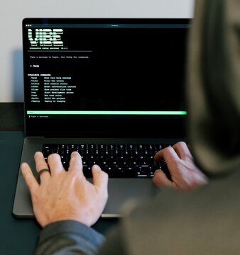 Middle Aged Man Turns Hacker in Hoodie After Using Vibe Coding Command Line Interface Artificial Intelligence Large Language Model Assistant Concept