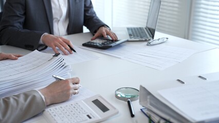Obraz na płótnie Canvas Accountants processing financial documents and taxes, managing corporate finance in a modern office. Audit and taxes in business