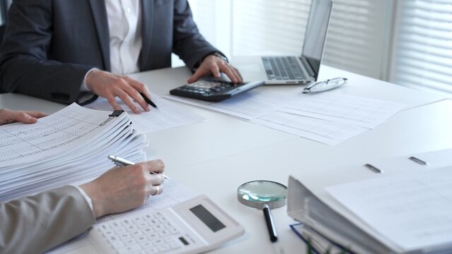 Accountants processing financial documents and taxes, managing corporate finance in a modern office. Audit and taxes in business