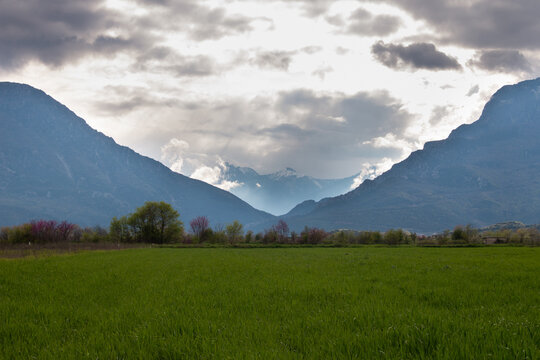Pyli gorge with Kerketion mountain south Pindus Thessaly Greece wheat field and cloudy sky spring landscape