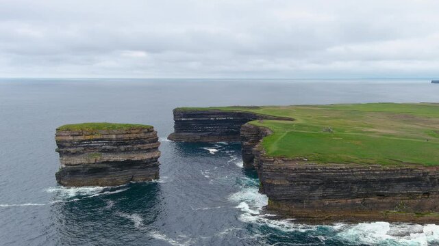 Aerial view of stunning Downpatrick Head coastal landmark with iconic Dun Briste sea stack. Dramatic cliffs and waves. Wild Atlantic Way Signature Discovery Point. Speed ramp effect.