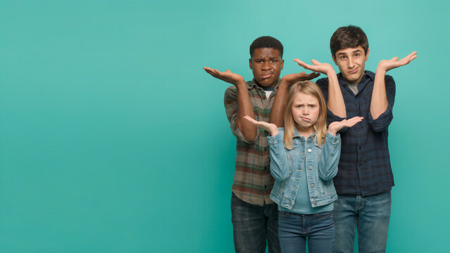 Group of young people shrugging with hands out in doubt against a turquoise background