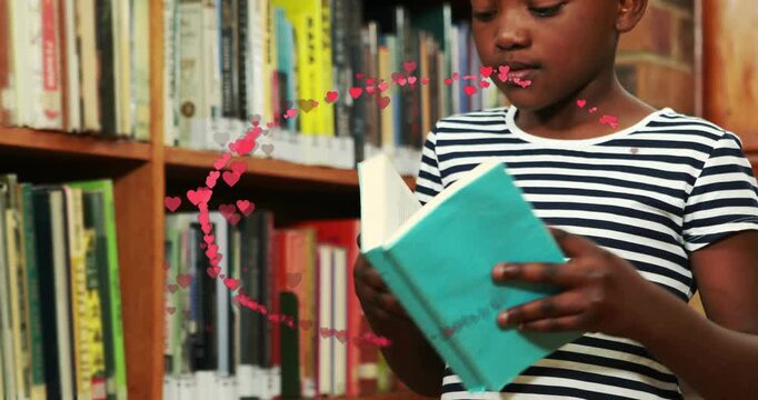 Kid opening teal book reading and flipping pages in library learning while hearts swirling around