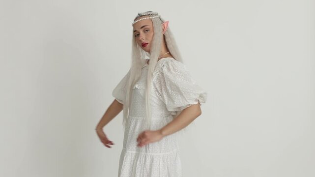 Beautiful girl dressed as elf on white background