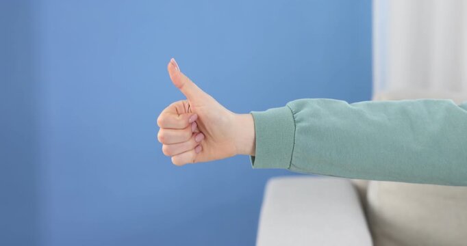 Woman showing thumbs up and thumbs down gestures indoors, closeup