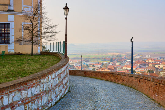 Serene pathway by historic building overlooking quaint european village