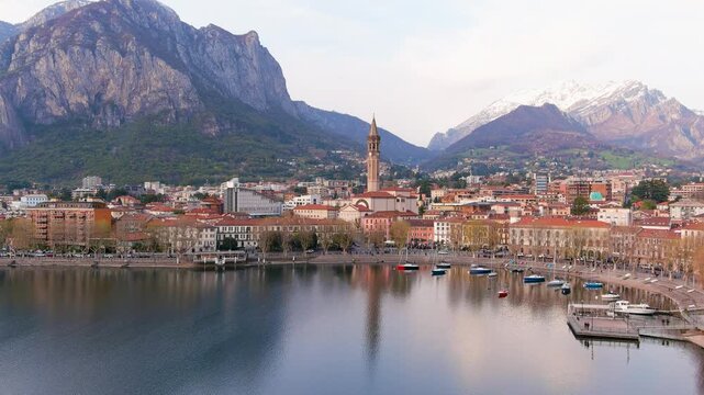 Aerial beautiful sunset cityscape of Lecco town and resort. Picturesque waterfront of Lecco town located between famous Lake Como and scenic Bergamo Alps mountains. Vacation destination in Italy.